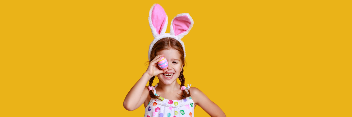 A girl excited about easter with easter bunny ears and an easter egg